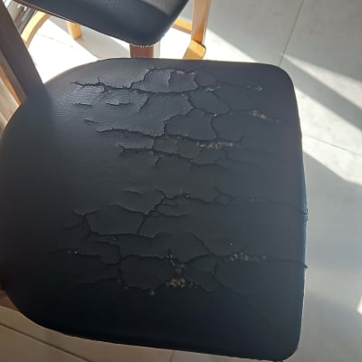 כיסא עם ריפוד סדוק ובלוי באור שמש