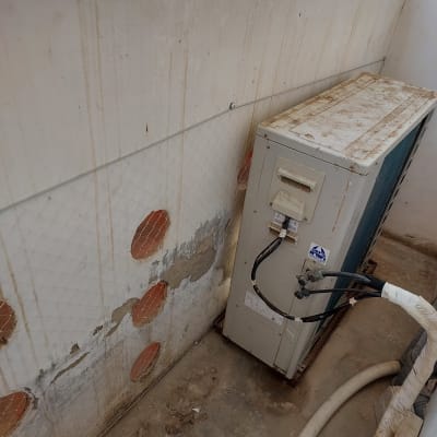 רשת יונים מותקנת על קיר ליד מזגן