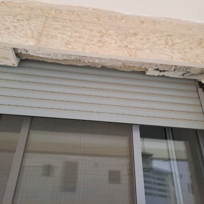 תריס גלילה מתכת עם קיר מתפורר מעליו