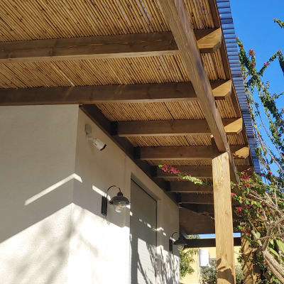 פרגולה מעץ עם גג במבוק בחצר