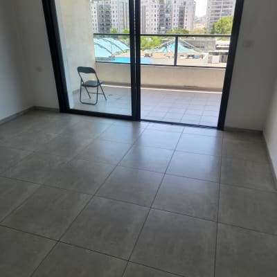 רצפה נקייה עם כיסא במרפסת ודלת זכוכית