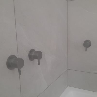 ברזים מותקנים על קיר אריחים בחדר אמבטיה