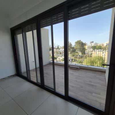 מרפסת עם רצפת עץ ודלתות זכוכית גדולות