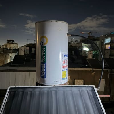 דוד שמש על גג בלילה עם שמיים מעוננים