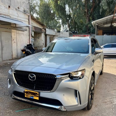 רכב חונה בחוץ ליד מבנה ישן ועצים