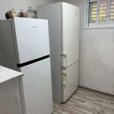 שני מקררים בחדר עם רצפת עץ