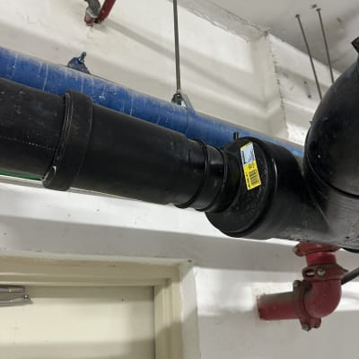 צינורות שחורים וכחולים בתקרה עם חיבורים