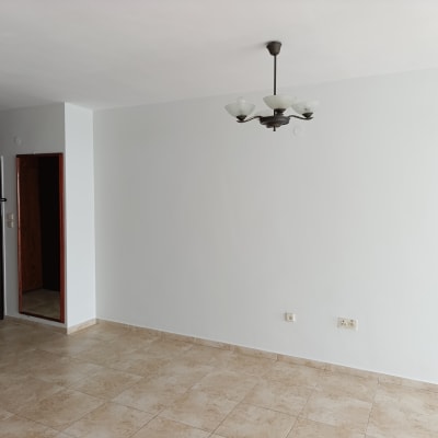 קיר צבוע בלבן עם מנורה תלויה ותקרה חלקה