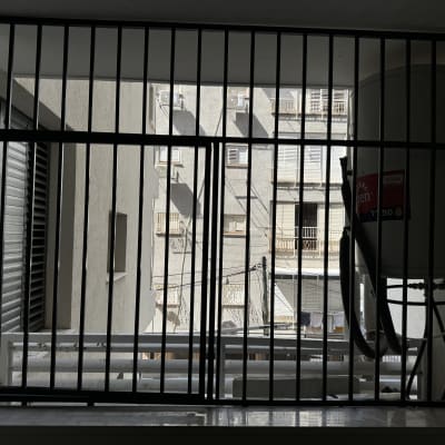 סורגי מתכת על חלון עם דוד שמש ברקע