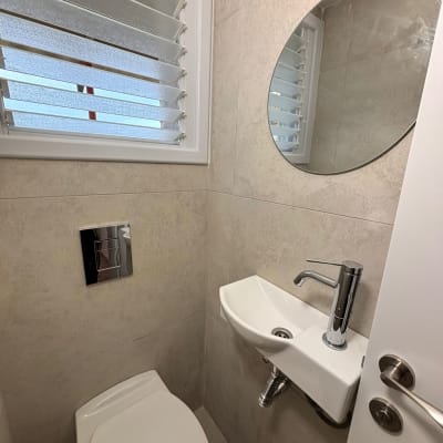 שירותים משופצים עם כיור קטן וברז כרום