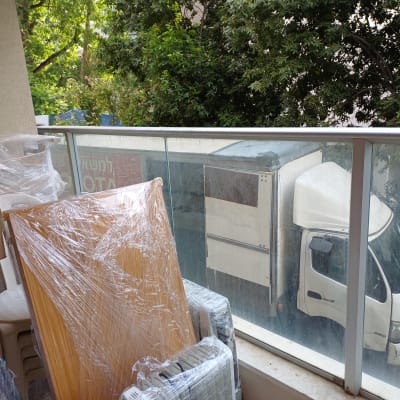 משאית הובלה וארגזים עטופים בניילון במרפסת