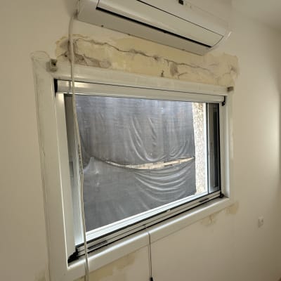 קיר עם סימני צבע מתקלף סביב חלון