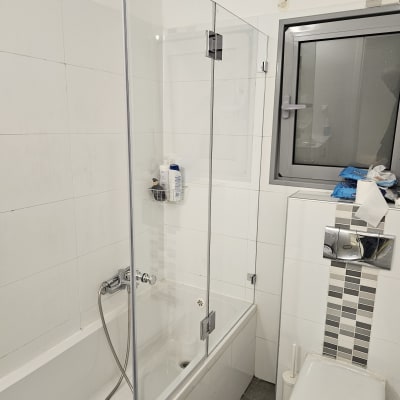 אמבטיה עם דלת זכוכית, ראש מקלחת ומוצרי רחצה