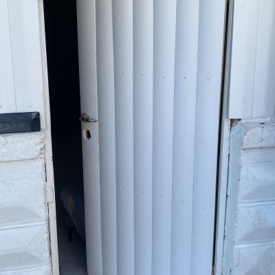 דלת לבנה פתוחה עם מסגרת מתכת