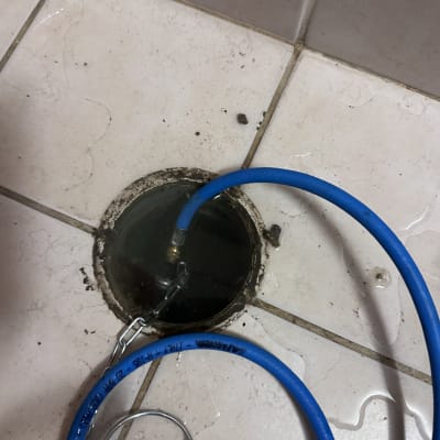 צינור כחול מחובר לניקוז ברצפה