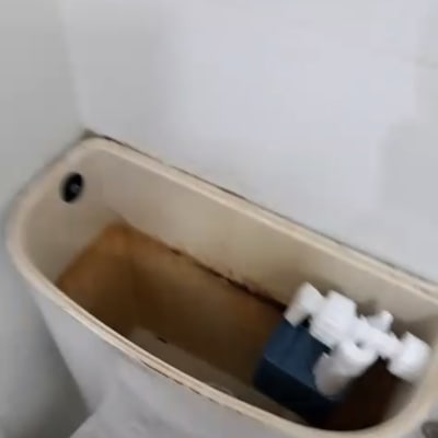 מיכל שירותים פתוח עם חלודה ומנגנון פנימי