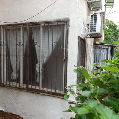 חלון עם סורגים וחוטים חשמליים מחוברים לקיר