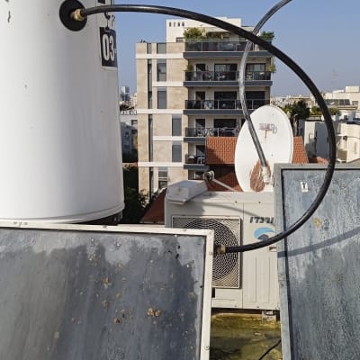 דוד שמש עם צינורות מחוברים על גג בניין