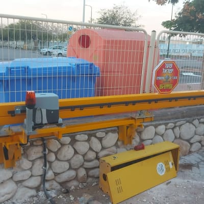 שער חשמלי עם מנוע ומחסום צהוב