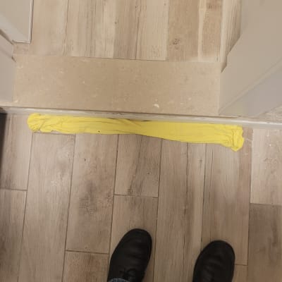 מגבת צהובה על רצפת עץ ליד דלת