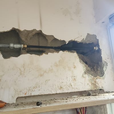 צינור מים חשוף בקיר עם חיבורים