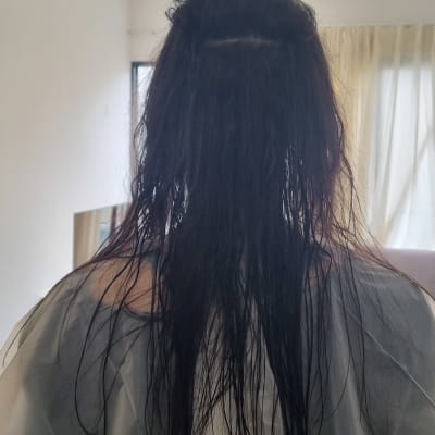 שיער רטוב מכוסה בגלימה במספרה