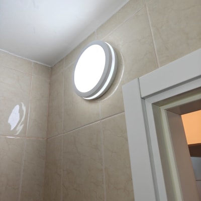 מנורה עגולה מותקנת על קיר בחדר אמבטיה