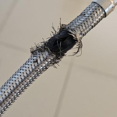 צינור מתכת עם קרע וחוטים חשופים