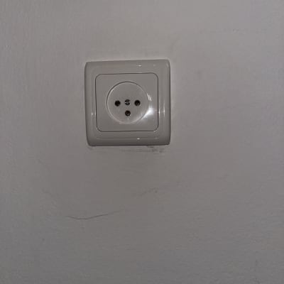 שקע חשמל עגול על קיר לבן