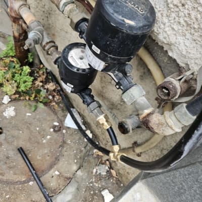 מד מים וצינורות מחוברים לקיר