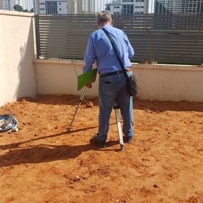 מודד בשטח עם ציוד מדידה על אדמה