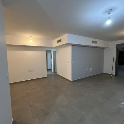 קירות צבועים בלבן, רצפה אפורה, תאורה בתקרה