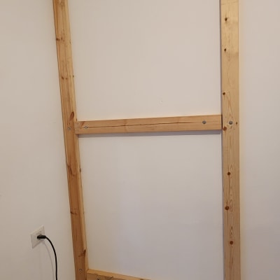 מסגרת עץ על קיר עם מקדחה וכבל חשמל