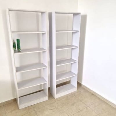 שני מדפים לבנים ריקים על רצפה בהירה