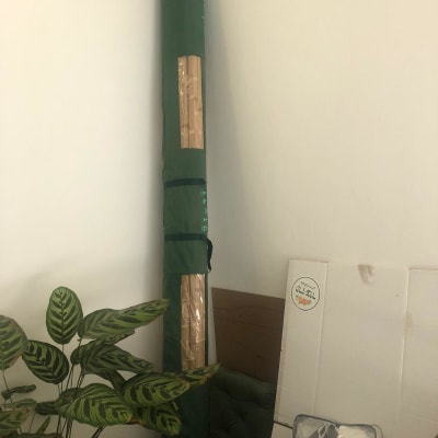 תיק ירוק עם ציוד ארוז בפינה ליד קיר