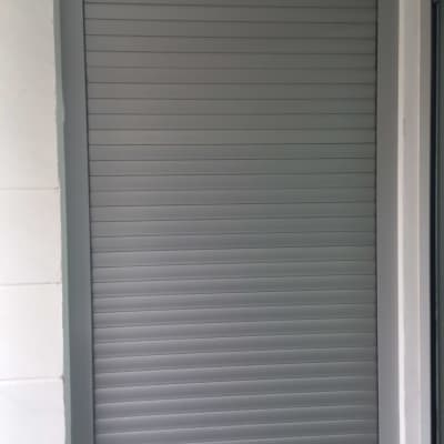 תריס גלילה אפור סגור במסגרת מתכת