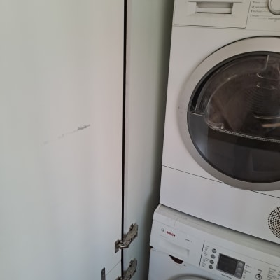 מכונת כביסה ומייבש בחדר כביסה עם ארון