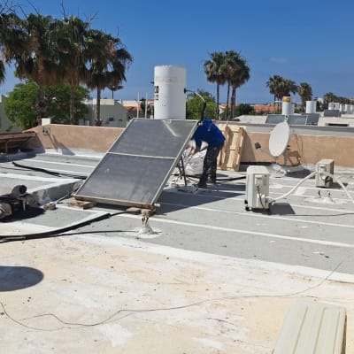 אדם עובד על איטום גג עם ציוד מתאים