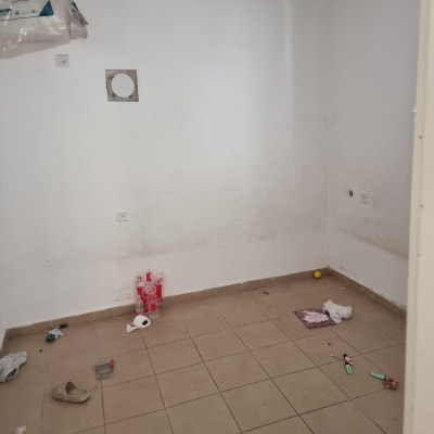 חדר ריק עם קירות לבנים וכלים על הרצפה