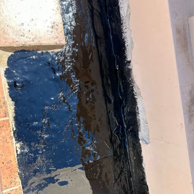 איטום עם חומר שחור על רצפה ובקיר