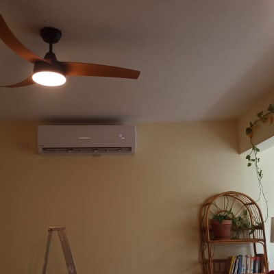 מזגן מותקן על קיר בחדר עם מאוורר תקרה