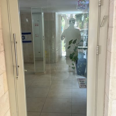 דלת זכוכית עם ידית מתכת ומנגנון סגירה אוטומטי