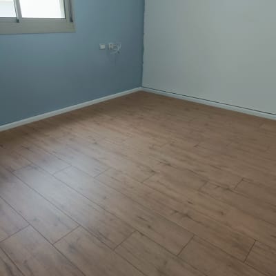 רצפת פרקט עץ בחדר עם קירות כחולים