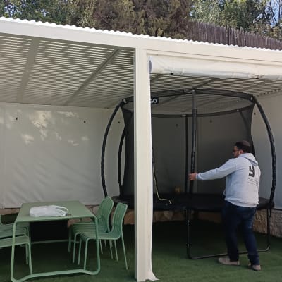 שני אנשים עובדים על התקנת פרגולה בחצר