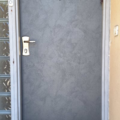 דלת אפורה עם ידית כסופה ומפתן שחור