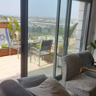 תריסים זכוכית גדולים במרפסת עם נוף עירוני