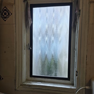 חלון עם זכוכית מט במבנה ישן