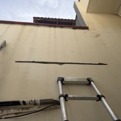 סולם ליד קיר עם סדק לתיקון איטום