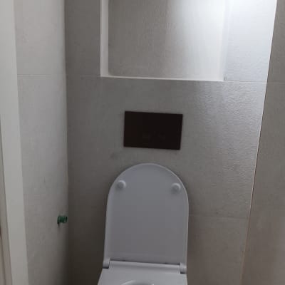 אסלה בחדר אמבטיה עם קיר לבן