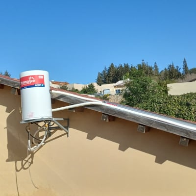 דוד שמש מותקן על גג בית עם שמיים כחולים